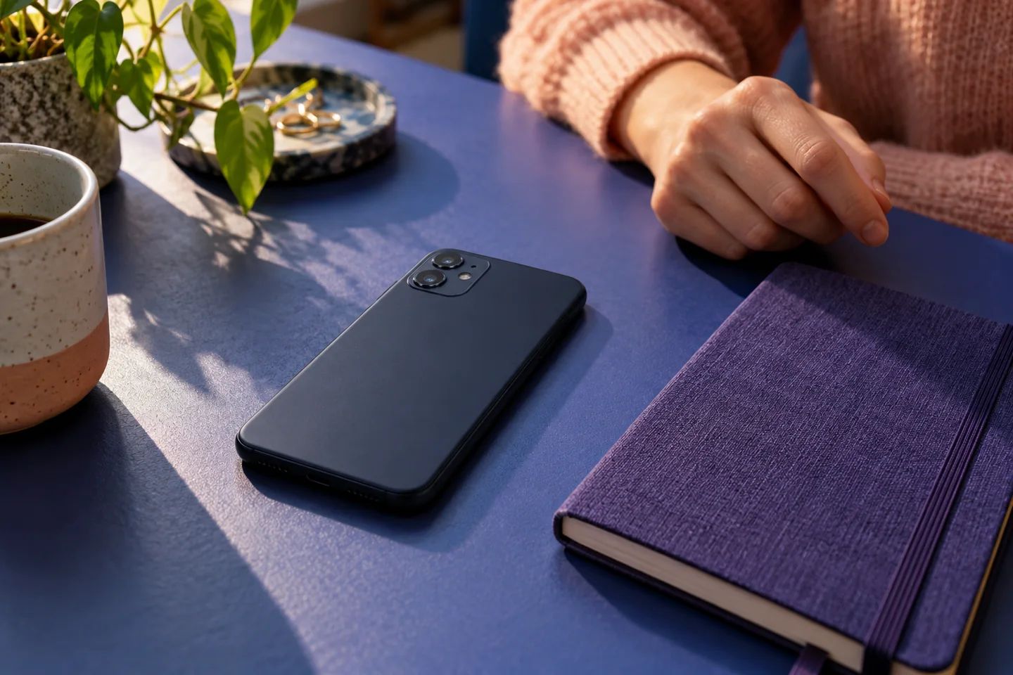 An unbranded phone face down beside a notebook
